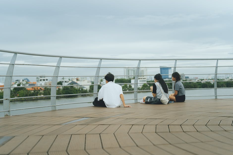 Three people sitting on a riverside deck overlooking the cityscape in Ho Chi Minh City, Vietnam.