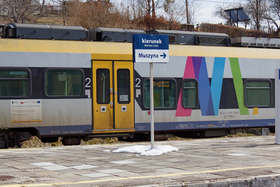 A vibrant train at Krynica-Zdrój station heading to Muszyna during winter. Scenic Polish railway.