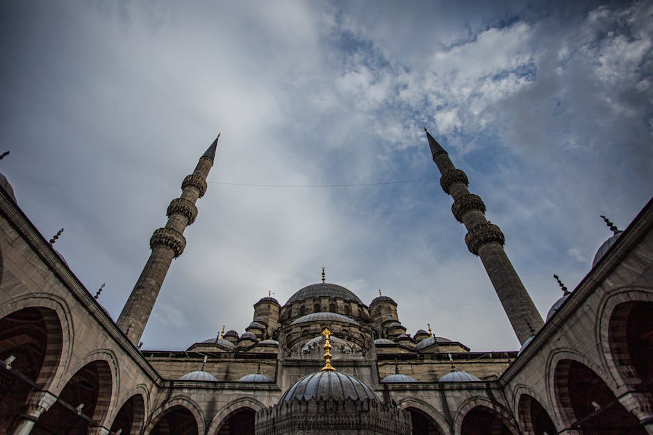 Breathtaking view of Istanbul's Yeni Mosque against a dramatic sky, showcasing its iconic architecture.
