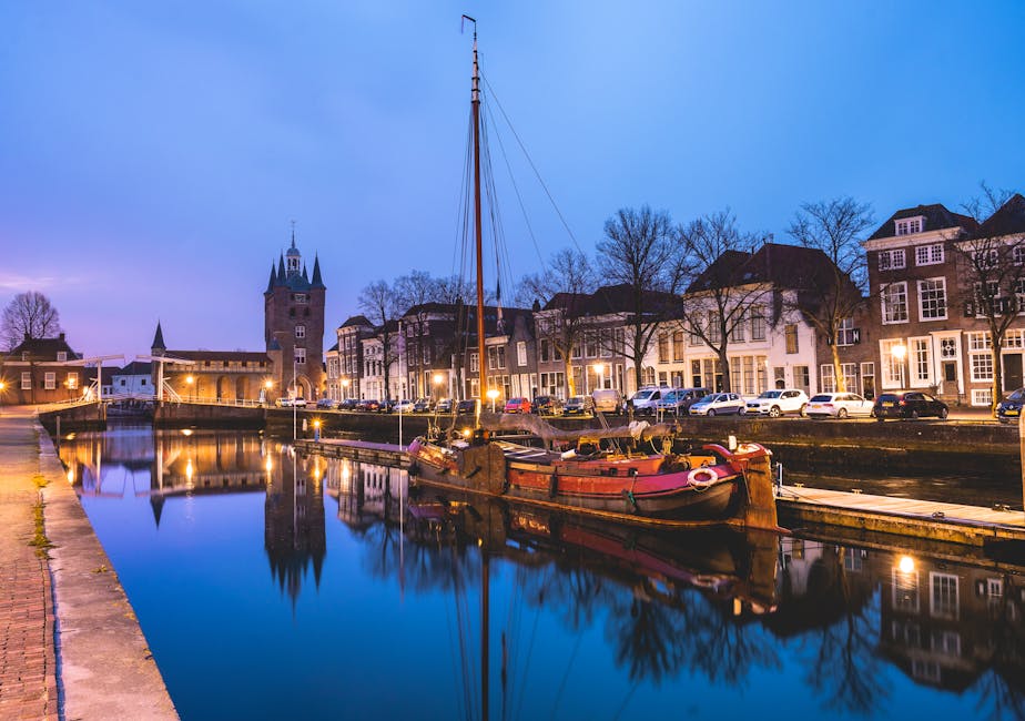 Evening view of the Zierikzee canal with a boat and historic buildings, reflecting a serene urban landscape.